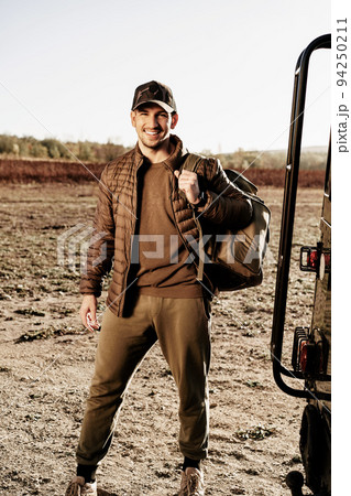 Young male traveler in hiking outfit standing near his car 94250211