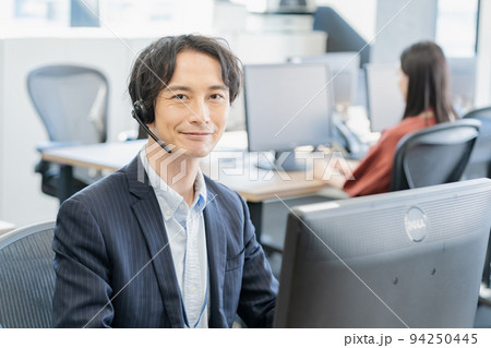 コールセンターで働く男性オペレーター コールセンターで働く男性オペレーター 94250445