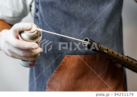 Close up of a man in apron lubricates the mechanism of the weapon with oil 94251179