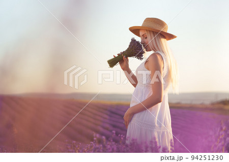 Portrait o charming blonde girl smells lavender flowers in lavender field 94251230