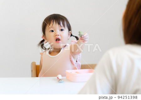 ご飯を食べる女の子とお母さん 94251398