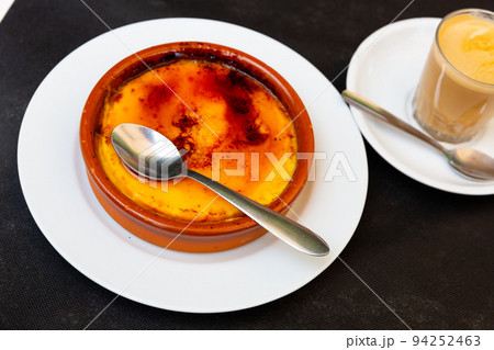 Delicious traditional Spanish dessert - Crema catalana served with spoon in clay bowl 94252463