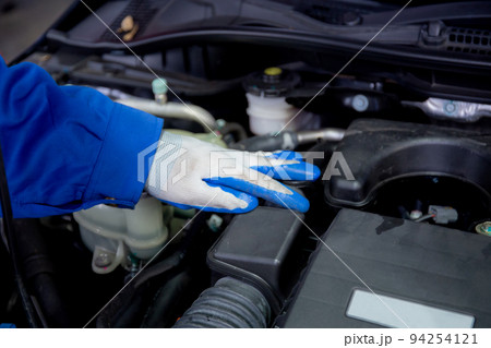 Closeup hands of man is mechanic repairing engine of car in the garage, auto service. 94254121