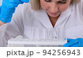 Close up research chemist takes samples for research and works in a laboratory with a micropipette 94256943