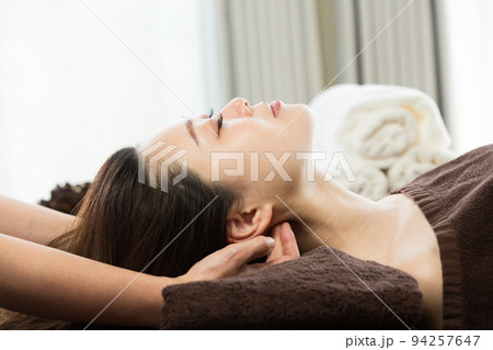 女性は首のマッサージを受けている。 女性は首のマッサージを受けている。 94257647