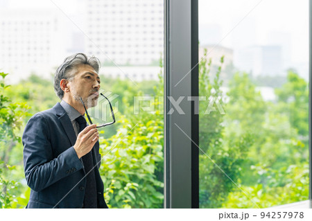 オフィスで眼鏡を外すエグゼクティブ男性 94257978