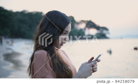 Holiday concept of 4k Resolution. Asian woman using mobile phone on the beach. 94258079