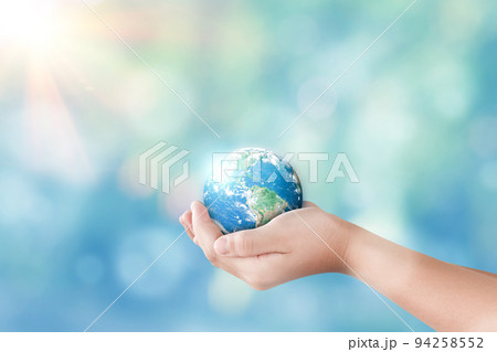 Hands holding global on blurred nature background 94258552