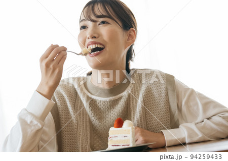 ショートケーキを食べる女性 94259433