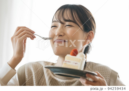 ショートケーキを食べる女性 94259434