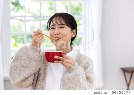 スープを美味しそうに飲む女性 94259574