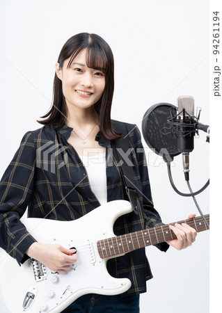 エレキギターを弾きながら歌う若い女性 94261194
