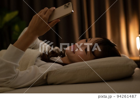 ベッド・寝室でスマホを操作する女性 94261487