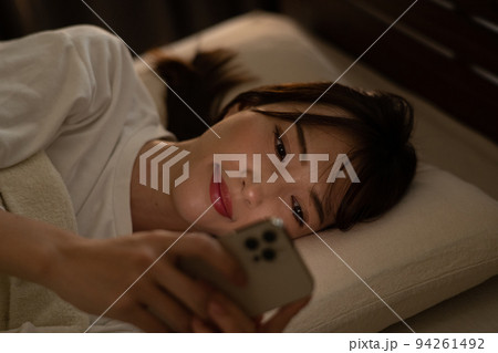 ベッド・寝室でスマホを操作する女性 94261492