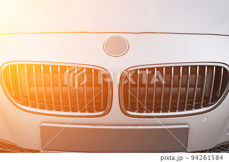 Predatory car headlight with blue lights and hood of powerful grey blue car sports car with matte grey paint and wheel with blue disc Predatory car headlight with blue lights and hood of powerful grey blue car sports car with matte grey paint and wheel with blue disc 94261584