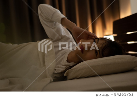 ベッドで頭痛・不眠症を感じる寝付けない女性 94261753