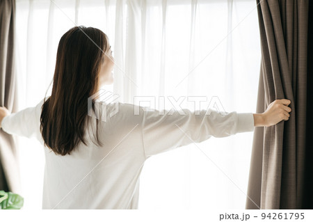 カーテンを開ける女性・起床イメージ 94261795