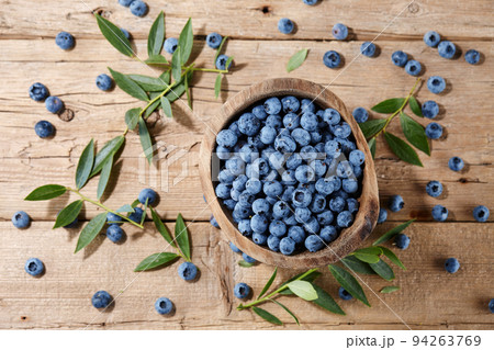 Fresh blueberries in bowl on wooden planks Fresh blueberries in bowl on wooden planks 94263769
