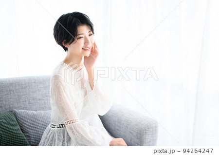 ソファでお肌を気にする女性 やや俯瞰 ソファでお肌を気にする女性 やや俯瞰 94264247