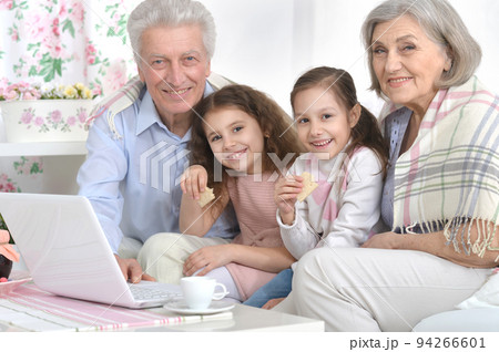 Grandfather and grandmother with children are sitting with a laptop Grandfather and grandmother with children are sitting with a laptop 94266601