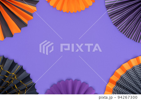 Halloween background. Bright paper fans are laid out in the form of a frame on a purple background. 94267300