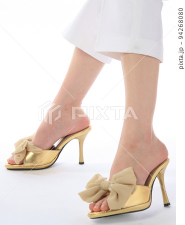ゴールド色のサンダルを履いている足 94268080