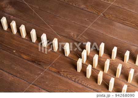 Rows of dominoes standing on wooden table Rows of dominoes standing on wooden table 94268090