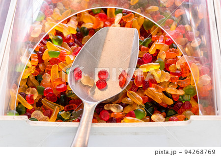 Candy sweets jelly, sweet chewy candies in different shapes at candy shop. Fruit jelly in shop window, sweets for Halloween. Candy stand with gummi colorful candies. 94268769