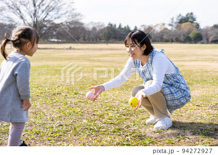 公園の芝生広場で遊ぶ園児と保育士 公園の芝生広場で遊ぶ園児と保育士 94272927
