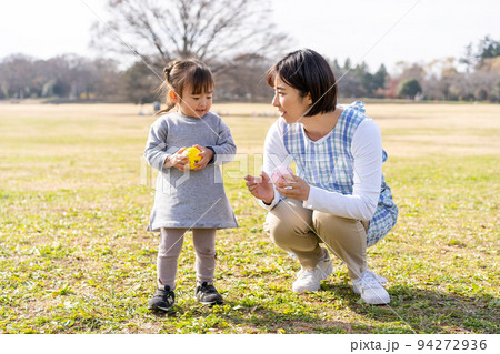 公園の芝生広場で遊ぶ園児と保育士 公園の芝生広場で遊ぶ園児と保育士 94272936