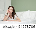 Beautiful thouhtful woman on bed in modern apartment 94273786