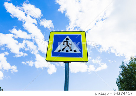 Blue and white pedestrian crossing sign on the sky background 94274417