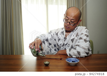 お酒楽しむ浴衣中年男性 94274918