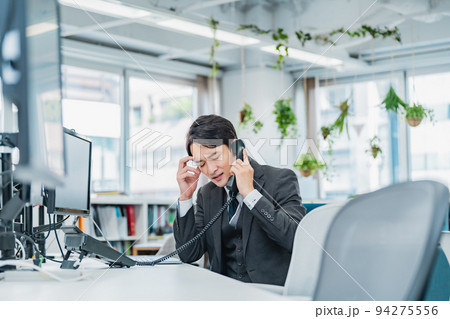クレーム電話応対をする男性 94275556