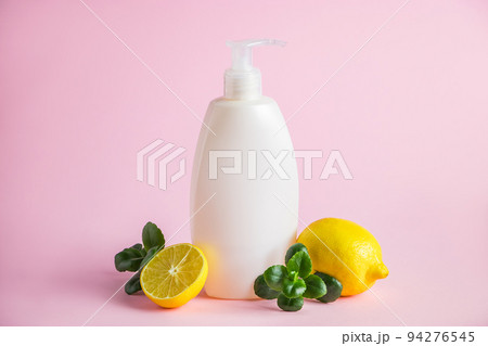 Organic cosmetics with lemon oil. Bottle of moisturizer with citrus on a pink background. 94276545