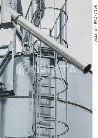 Ladder on silo for storage grain after harvest. Detail of agricultural equipments Ladder on silo for storage grain after harvest. Detail of agricultural equipments 94277166