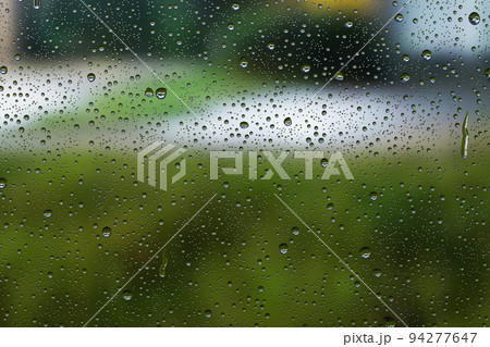 雨滴のガラス窓に映る緑の風景 雨滴のガラス窓に映る緑の風景 94277647