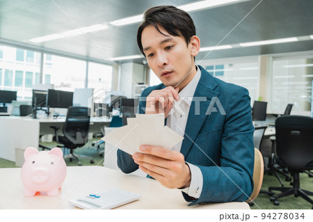 お金の計算をするビジネスマン 94278034