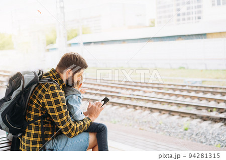 back shot of caucasian man holding children hands walking along platform going to take train back shot of caucasian man holding children hands walking along platform going to take train 94281315