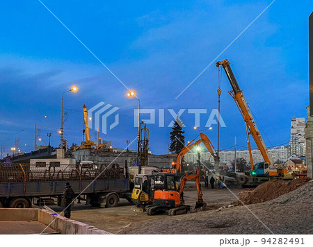 construction of a broken bridge on a busy road. heavy trucks brought a metal frame for the overpass. construction machinery carries concrete blocks construction of a broken bridge on a busy road. heavy trucks brought a metal frame for the overpass. construction machinery carries concrete blocks 94282491