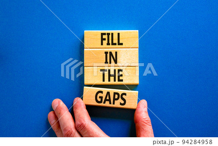 Fill in the gaps symbol. Concept words Fill in the gaps on wooden blocks on a beautiful blue table blue background. Businessman hand. Business, motivational and fill in the gaps concept. Fill in the gaps symbol. Concept words Fill in the gaps on wooden blocks on a beautiful blue table blue background. Businessman hand. Business, motivational and fill in the gaps concept. 94284958