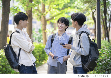 笑顔で会話をする3人の男子大学生　イメージ 94286454