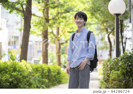 カメラ目線の笑顔の若い男性 94286724