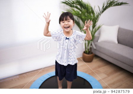 トランポリンでジャンプして遊ぶ5歳の女の子 94287579