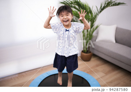 トランポリンでジャンプして遊ぶ5歳の女の子 94287580