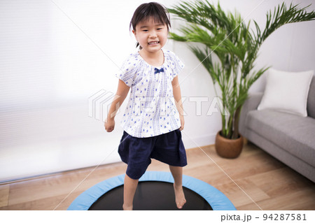 トランポリンでジャンプして遊ぶ5歳の女の子 94287581