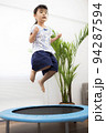 トランポリンでジャンプして遊ぶ5歳の女の子 94287594