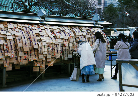 合格祈願、絵馬に願いを込める。湯島天神の春まだ浅き頃の風物詩、梅の花もチラホラ 94287602