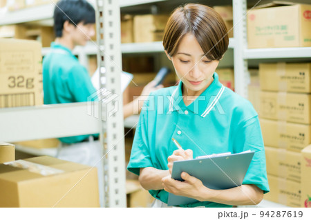 倉庫で在庫管理をする若い女性 倉庫で在庫管理をする若い女性 94287619