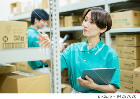 倉庫で在庫管理をする若い女性 倉庫で在庫管理をする若い女性 94287620